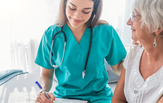 An image of a young medical student assisting an elderly woman.