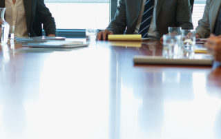 An image of executives sitting around a board room table.